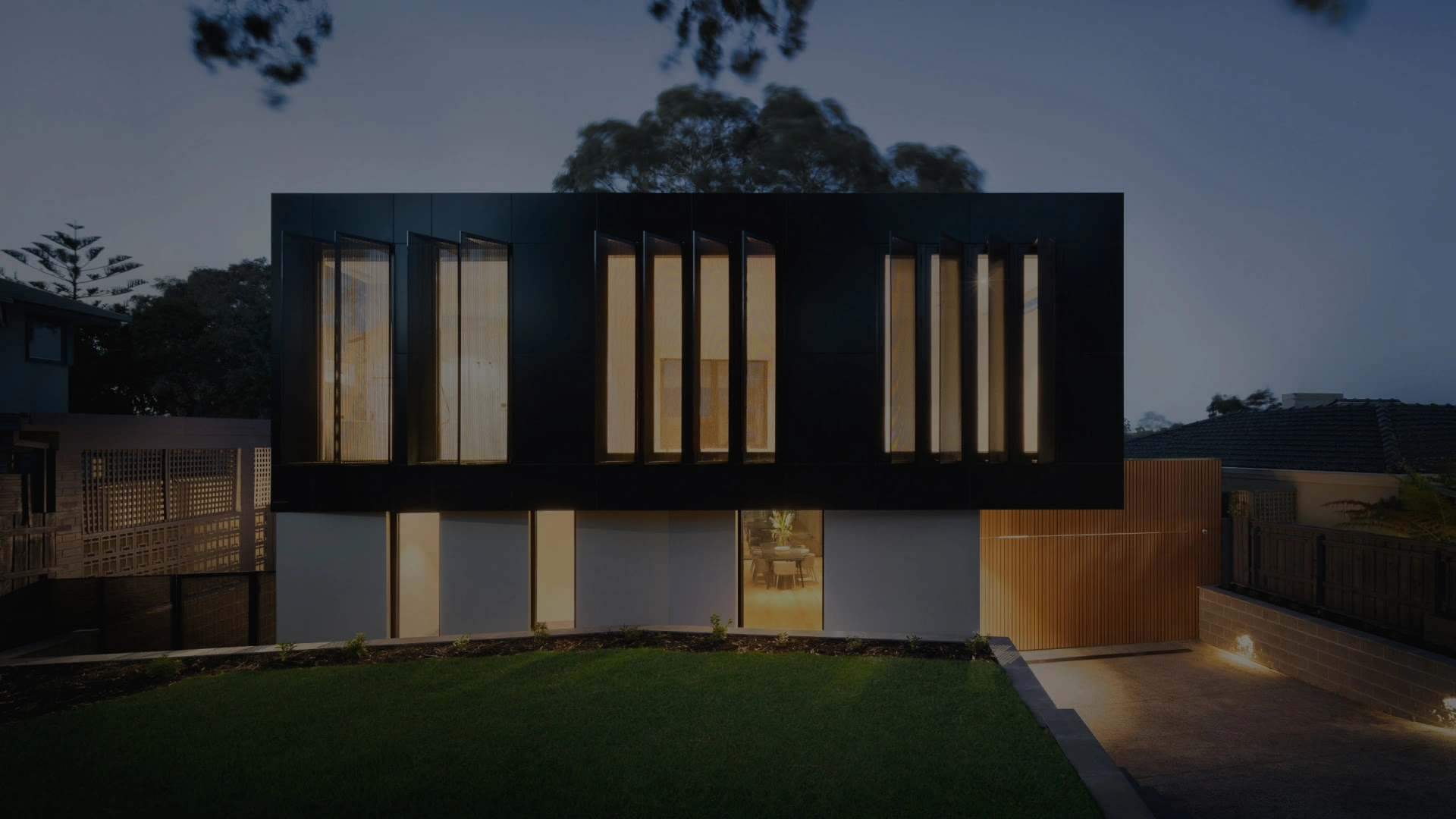 Casa do estilo moradia com fachada preta e branca com luzes ligadas